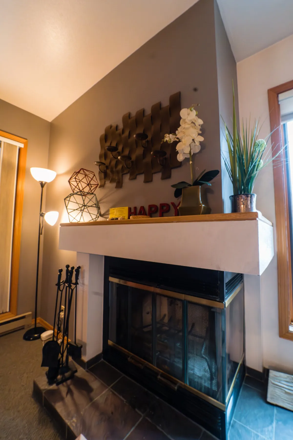 A warm, inviting interior with a fireplace, decorative wall art, and cozy furnishings. The space is styled for relaxation after a day spent outdoors, perfect for fireside lounging or intimate gatherings.
